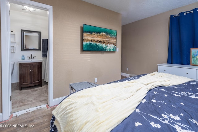 bedroom with connected bathroom and sink