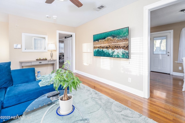 living room with wood-type flooring and ceiling fan