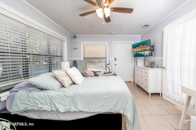 bedroom with light tile patterned floors, a textured ceiling, ceiling fan, and crown molding