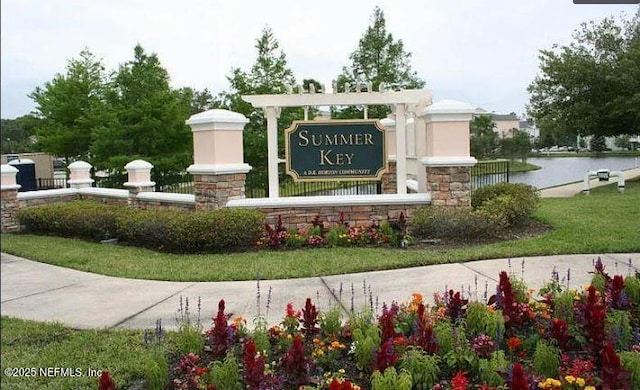 community sign featuring a water view