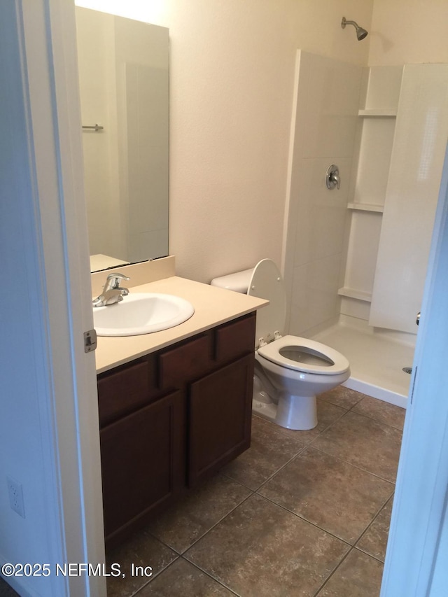 bathroom with walk in shower, vanity, and toilet