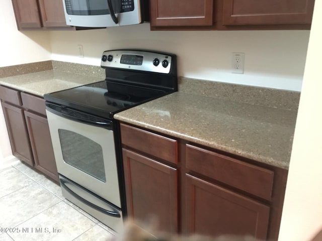 kitchen featuring stainless steel electric stove and light tile patterned floors