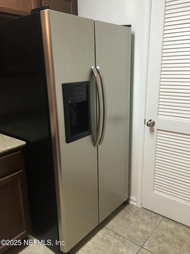 kitchen with stainless steel fridge with ice dispenser and light tile patterned flooring