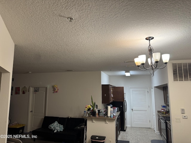 kitchen with a kitchen bar, kitchen peninsula, a textured ceiling, and a notable chandelier