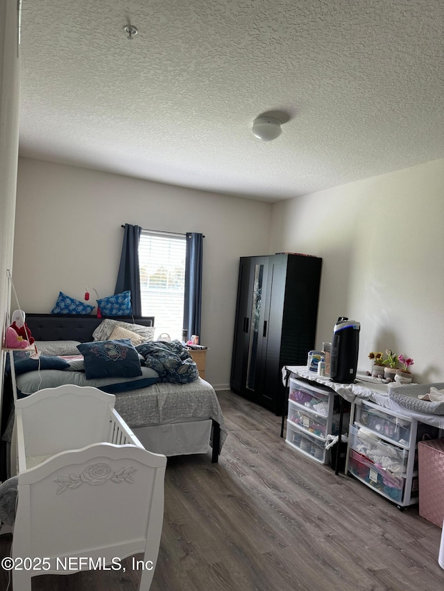 bedroom featuring wood-type flooring and a textured ceiling