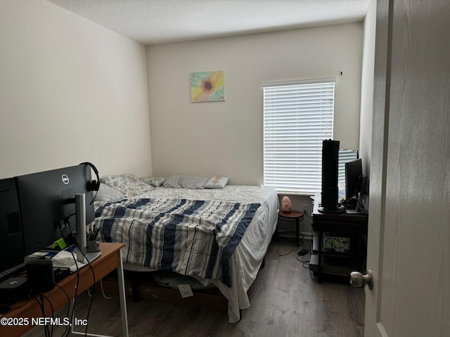 bedroom with a textured ceiling and dark wood-type flooring