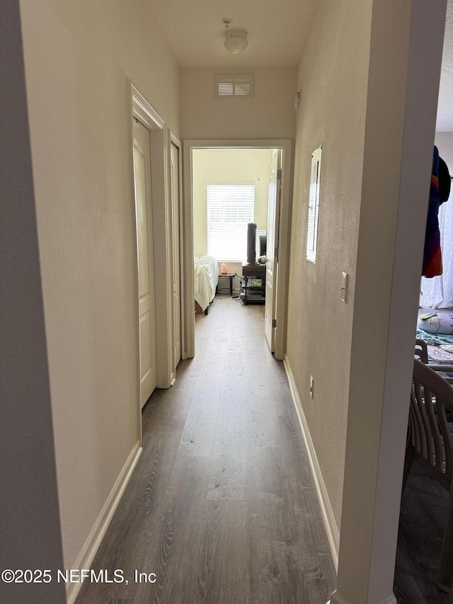 hallway with hardwood / wood-style flooring