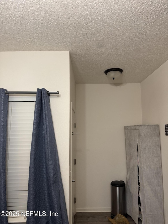 bathroom featuring hardwood / wood-style floors and a textured ceiling