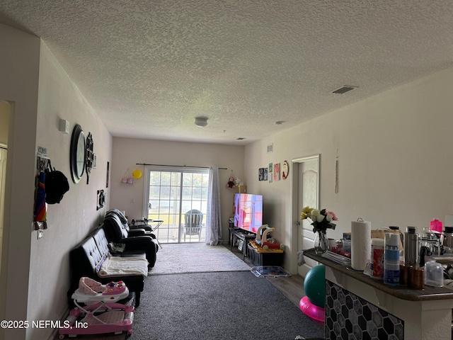 carpeted living room featuring a textured ceiling