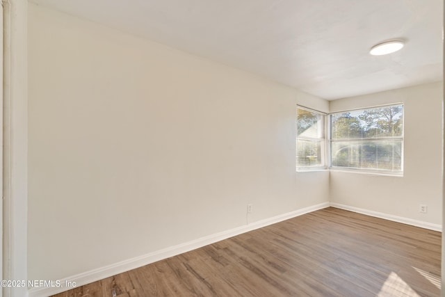 unfurnished room with hardwood / wood-style flooring