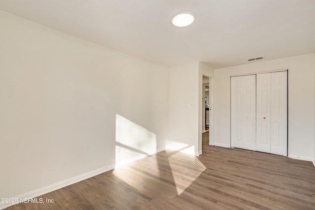 unfurnished bedroom with wood-type flooring and a closet