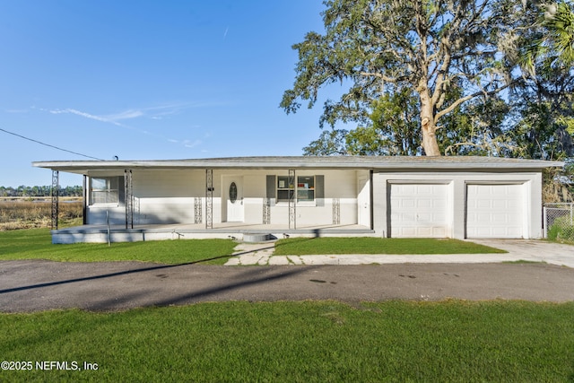 view of front of home featuring a garage, covered porch, and a front yard