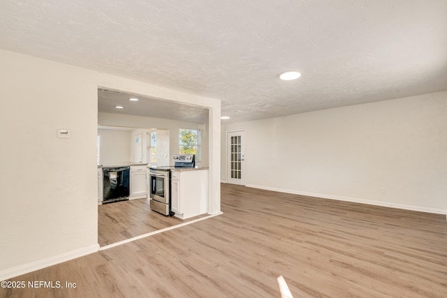 unfurnished living room featuring light hardwood / wood-style flooring and a textured ceiling