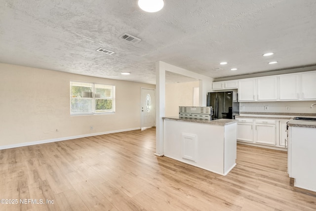 kitchen featuring black refrigerator with ice dispenser, a textured ceiling, sink, light hardwood / wood-style floors, and white cabinetry