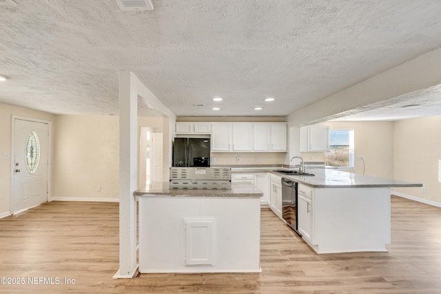 kitchen with black appliances, light hardwood / wood-style floors, white cabinetry, and sink