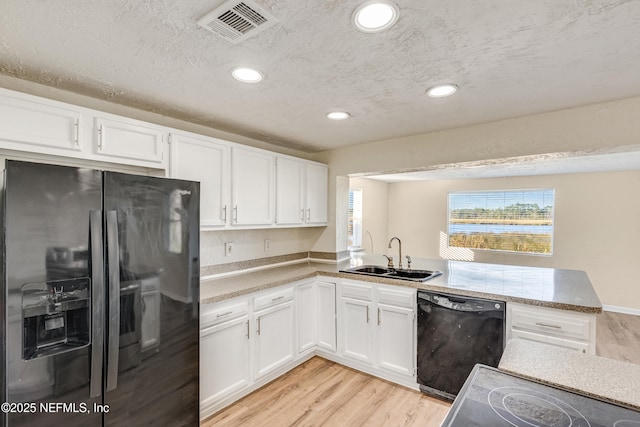 kitchen featuring black appliances, sink, light wood-type flooring, a textured ceiling, and white cabinetry