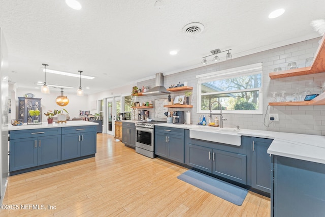 kitchen featuring stainless steel range with electric stovetop, sink, light hardwood / wood-style flooring, wall chimney exhaust hood, and tasteful backsplash