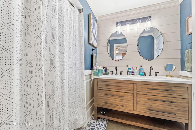 bathroom featuring a shower with shower curtain, vanity, wood walls, and ornamental molding