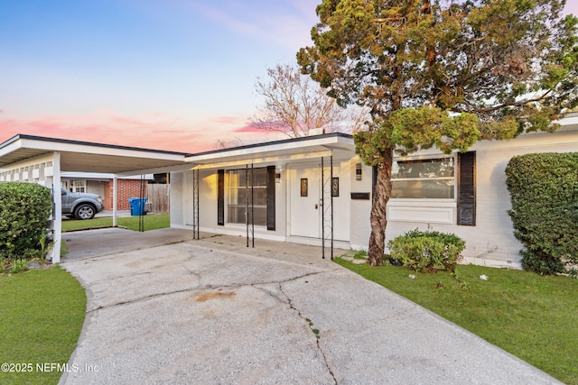 single story home with a lawn and a carport