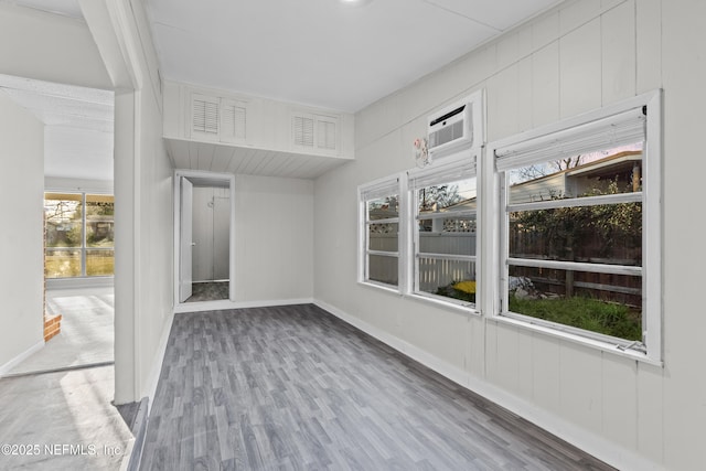 unfurnished sunroom featuring a wall unit AC