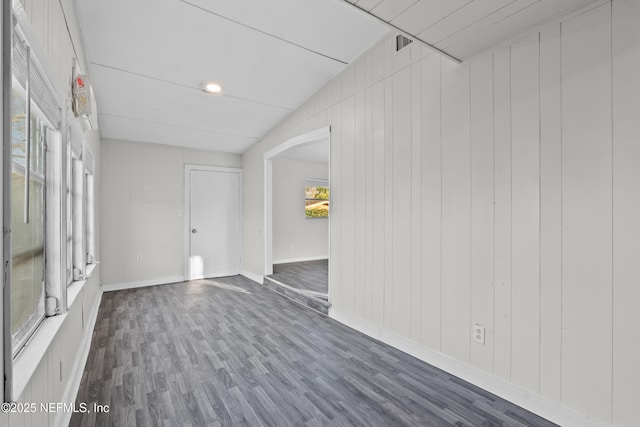 empty room with wood-type flooring and vaulted ceiling