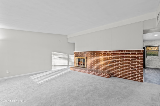 unfurnished living room featuring a brick fireplace and carpet floors