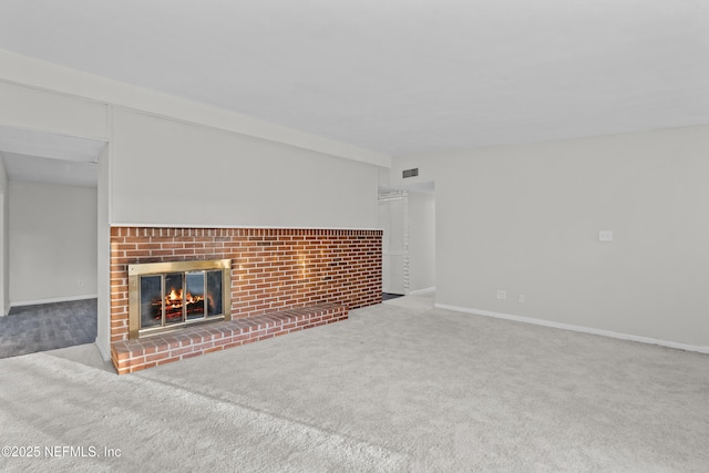unfurnished living room featuring a fireplace and light colored carpet
