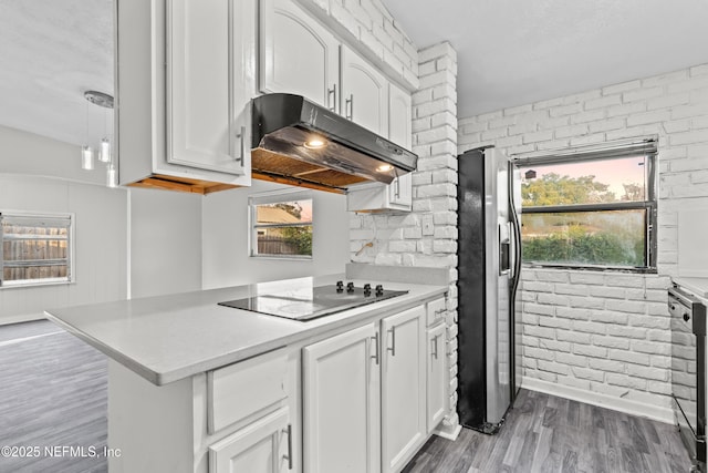 kitchen with white cabinetry, brick wall, black electric cooktop, and stainless steel fridge with ice dispenser