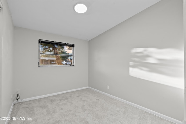 carpeted spare room with lofted ceiling
