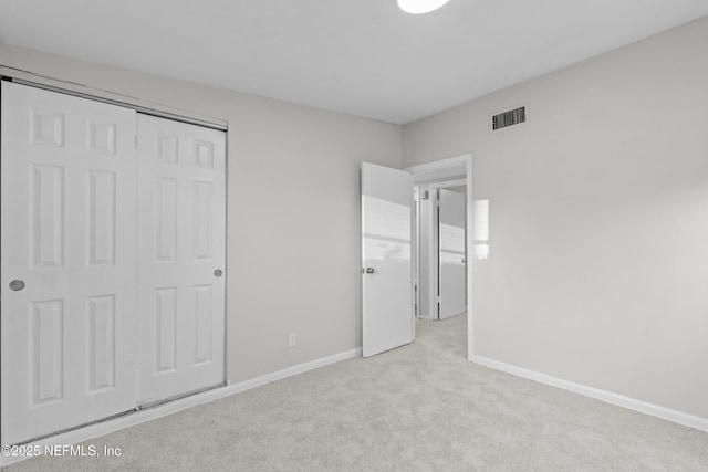 unfurnished bedroom with light carpet and a closet