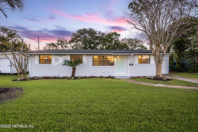 single story home featuring a yard and a garage