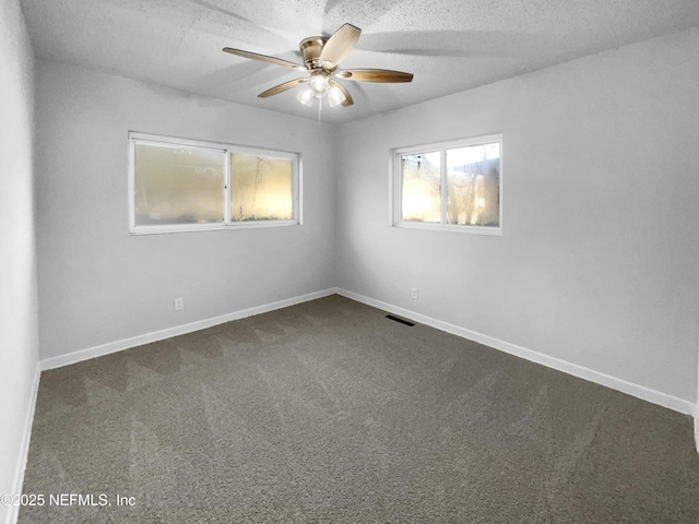 empty room with ceiling fan, carpet floors, and a textured ceiling