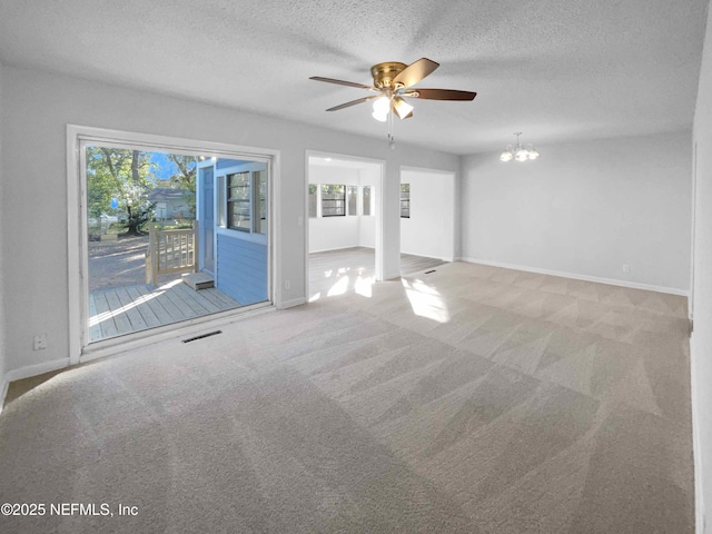 unfurnished living room with carpet flooring, a textured ceiling, and ceiling fan with notable chandelier