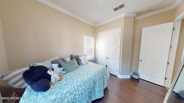 bedroom featuring ornamental molding, a closet, and dark wood-type flooring