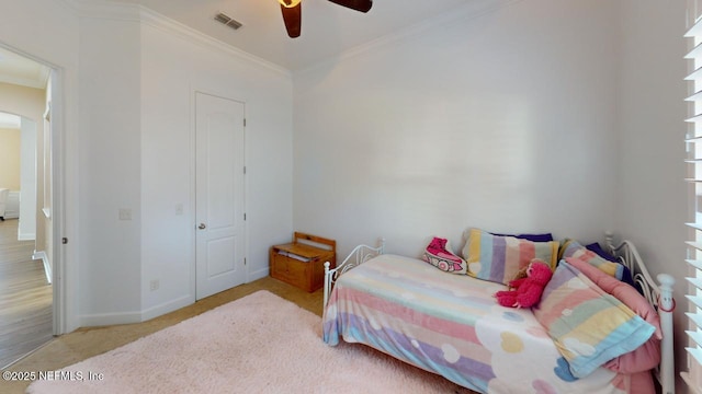 carpeted bedroom with ceiling fan and crown molding