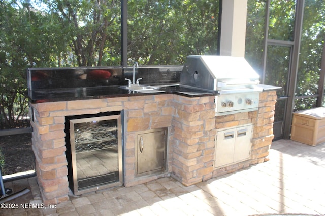 view of patio / terrace featuring a grill, exterior kitchen, sink, and wine cooler