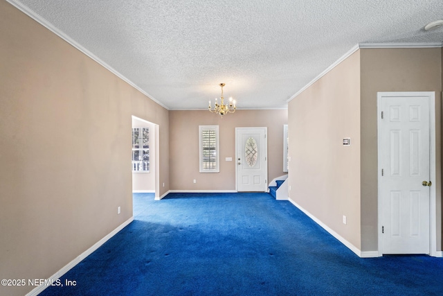 carpeted spare room with crown molding, a textured ceiling, and a chandelier