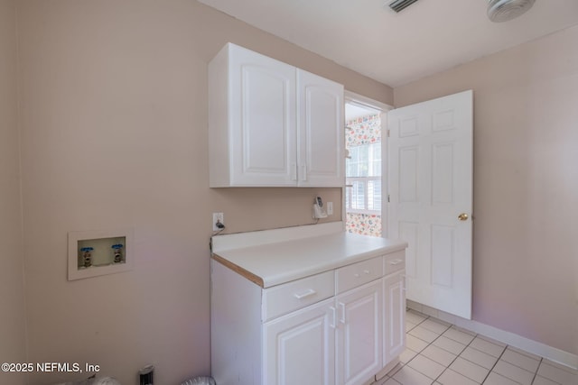 clothes washing area featuring washer hookup, light tile patterned floors, and cabinets