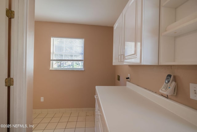 washroom featuring light tile patterned flooring, cabinets, and hookup for a washing machine