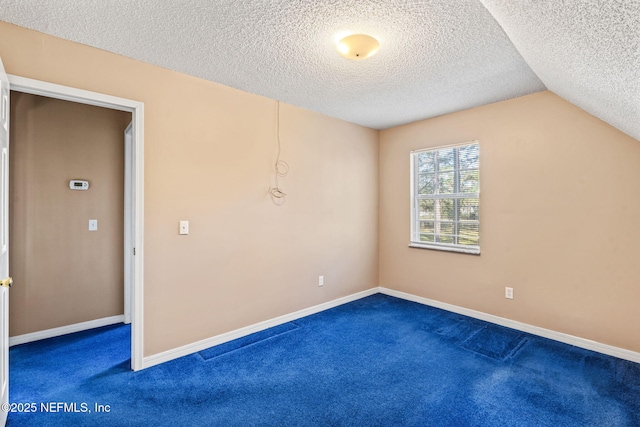 carpeted empty room with lofted ceiling and a textured ceiling