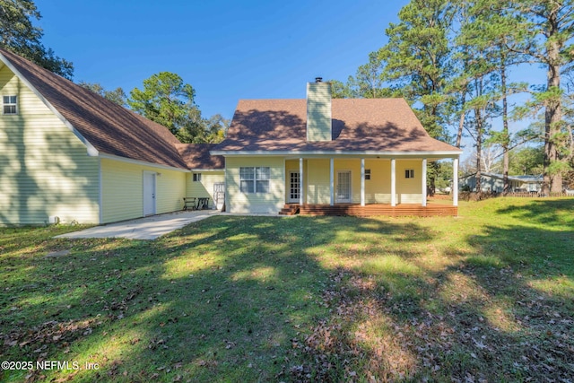 rear view of house with a patio area, covered porch, and a lawn