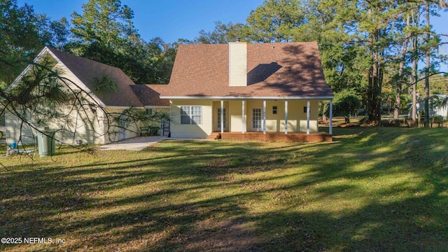 rear view of house with a lawn and a porch