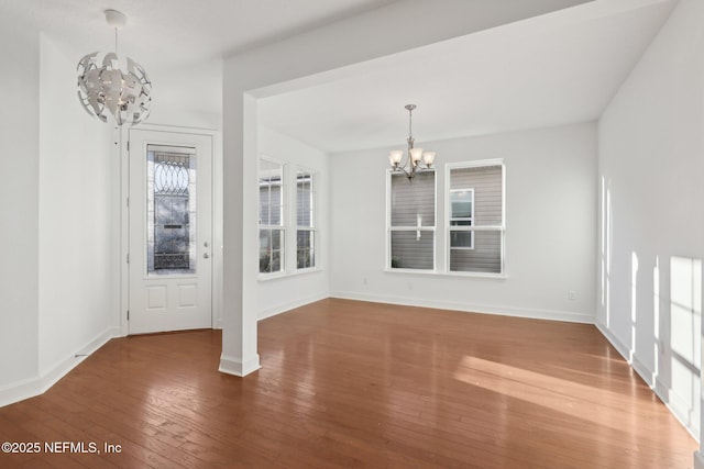 unfurnished dining area with hardwood / wood-style flooring and a notable chandelier