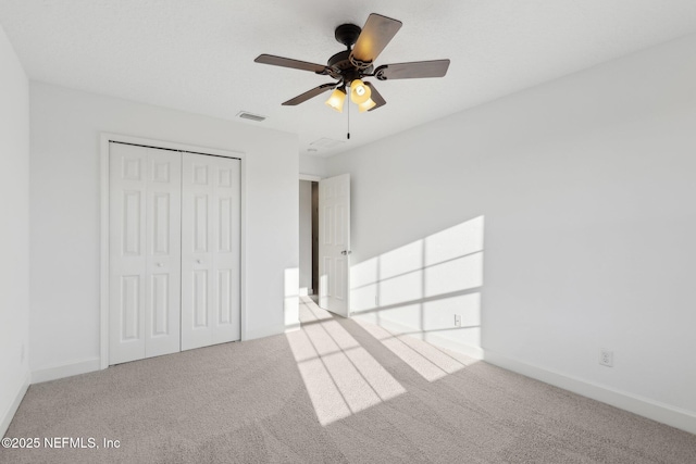 unfurnished bedroom featuring carpet flooring, ceiling fan, and a closet