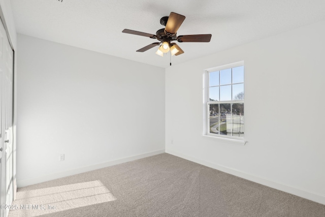 carpeted empty room featuring ceiling fan