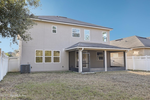 rear view of house with a yard, central AC, and a sunroom