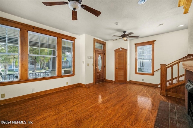 foyer entrance with hardwood / wood-style floors, a healthy amount of sunlight, ceiling fan, and a textured ceiling