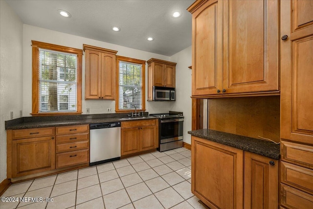 kitchen featuring light tile patterned flooring, appliances with stainless steel finishes, and sink