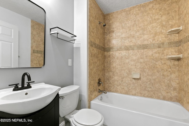 full bathroom with toilet, tiled shower / bath, vanity, and a textured ceiling