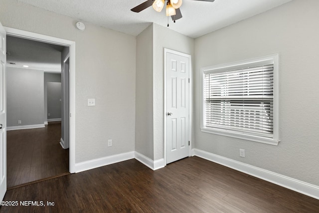 unfurnished bedroom featuring ceiling fan and dark hardwood / wood-style floors